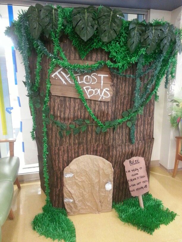 a fake tree stump with a sign that says lost boys on it and some plants growing out of it