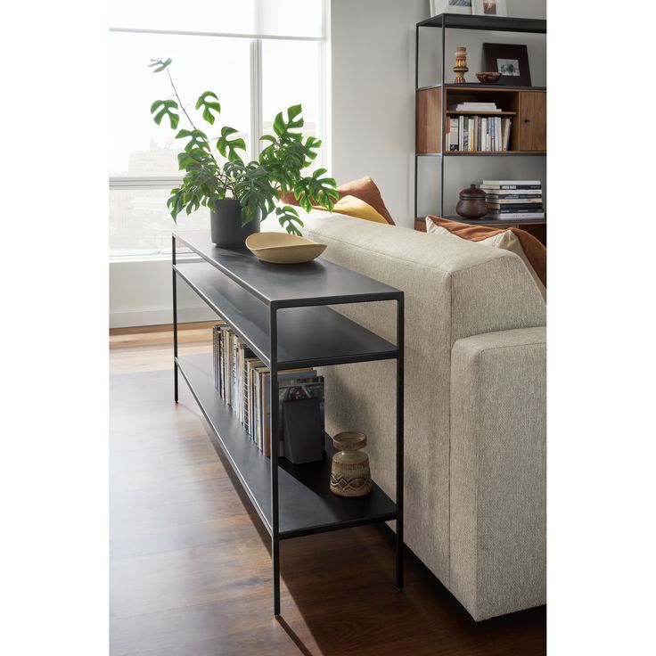 a living room with a couch, coffee table and bookshelf