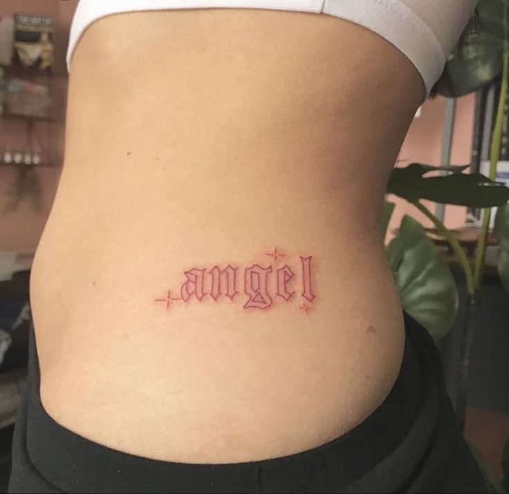 a woman's stomach with the word angel tattooed on her lower back and side