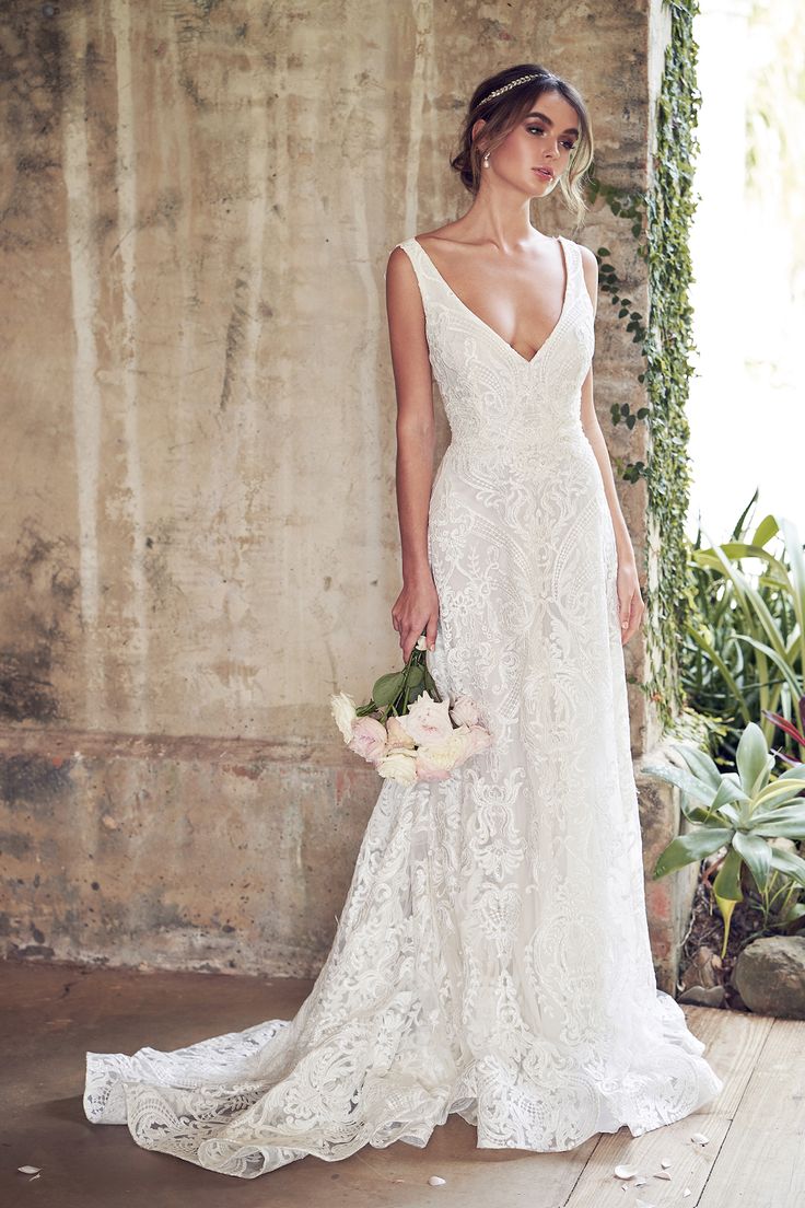 a woman in a wedding dress holding flowers