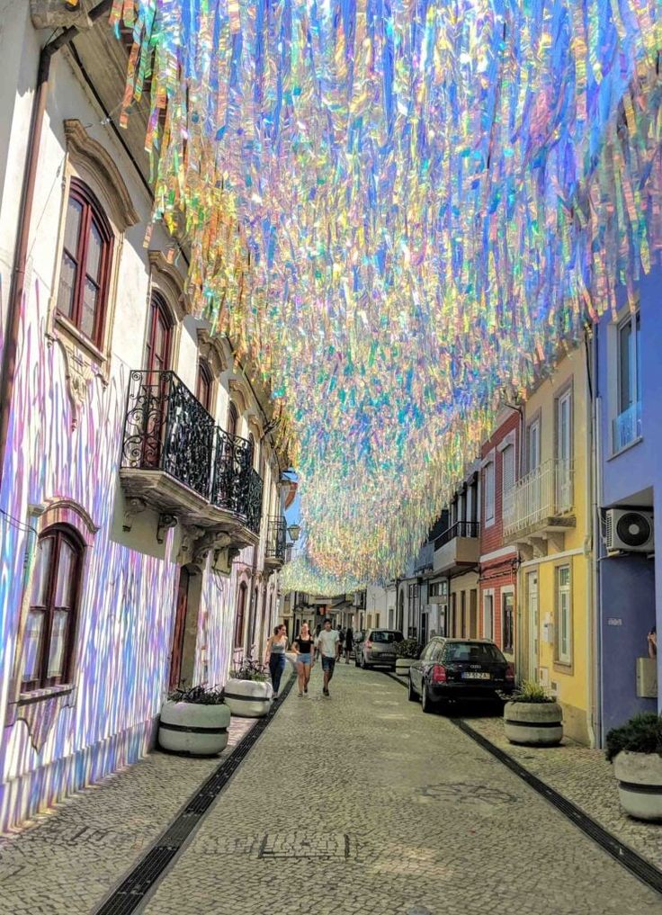 a street lined with lots of colorful lights hanging from the ceiling