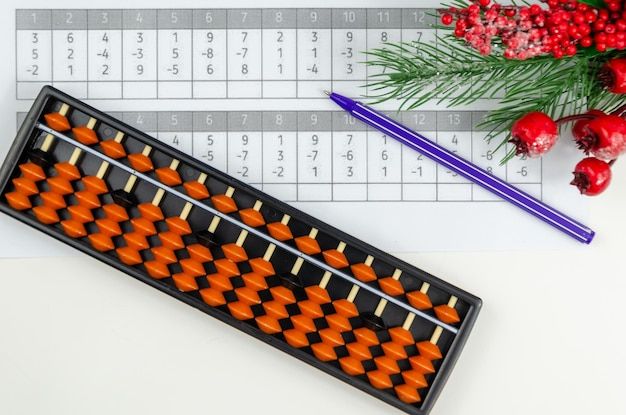 an orange and black abacusk sitting on top of a table next to some red berries