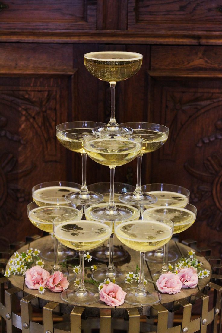 there are many wine glasses stacked on top of each other with flowers in the middle