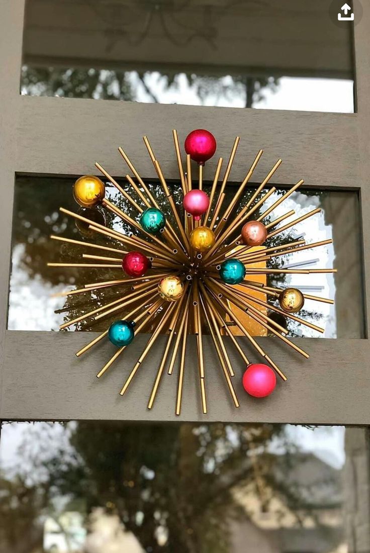 a sunburst is hanging on the side of a door with ornaments in it