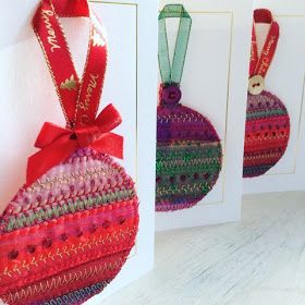 three christmas ornaments hanging from the side of a white wall next to two greeting cards