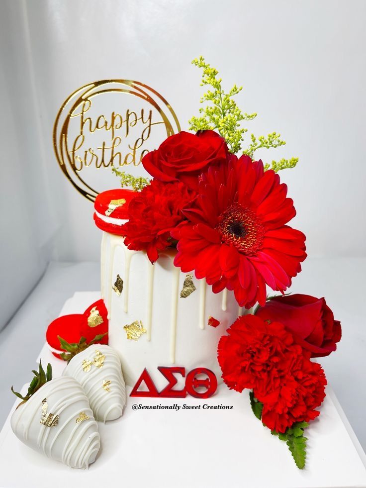 a birthday cake with red flowers and decorations