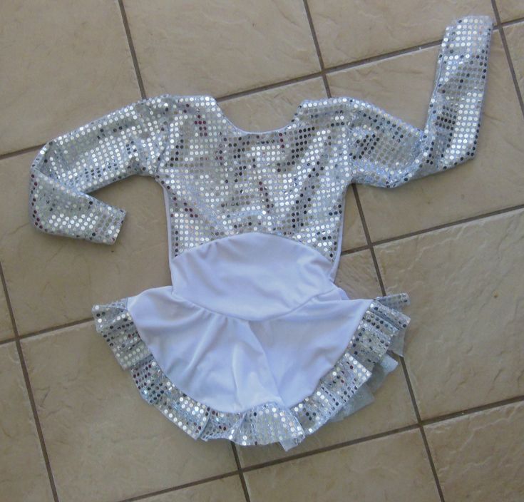 "This custom made, long-sleeved dress is made of a white VELVET with the sleeves and ruffled hem made of a silver confetti-sequined material.  Has a high neckline with lower back.  The skirt is gathered at the waist and attached underneath is the matching brief.  Measurements: SIZE        BUST          WAIST         HIPS          GIRTH   4-6          20-21\"          19-20\"         22-23\"         37-38\"  6x-7        22-23\"          20-21\"         23-25\"         41-42\" 8-10        24-25\" Fitted Long Sleeve Dresses For Dress-up Occasions, Fitted Long Sleeve Dress For Dress-up, White Winter Dress For Dress-up Occasions, White Sequined Dress For Costume Party, Fitted White Dress For Costume, White Fitted Dress For Costume, White Winter Costume Party Dress, White Sequin Dress For Winter, Fitted Sequin Costume Dress