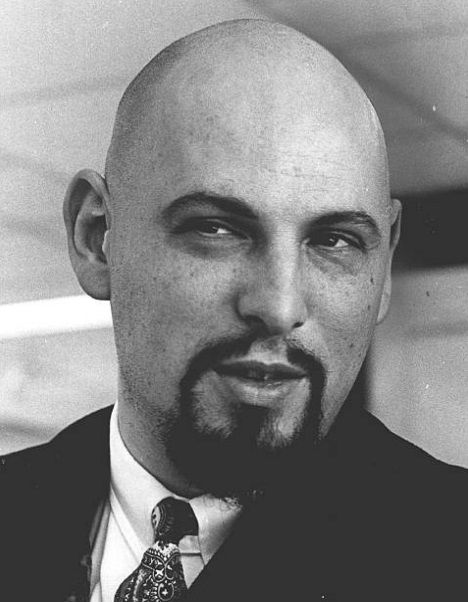 black and white photograph of a bald man wearing a suit