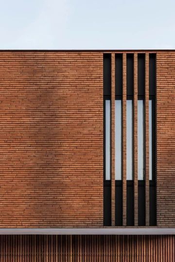 the side of a brick building with vertical windows