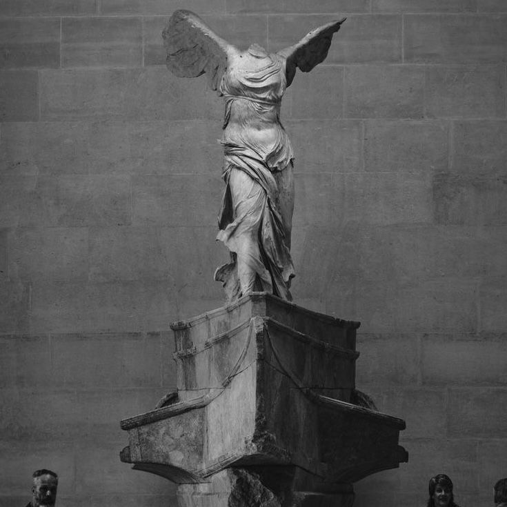 an angel statue on top of a stone pillar