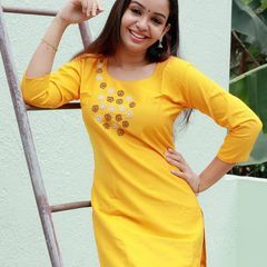 a woman standing next to a ladder smiling at the camera with her hands on her hips