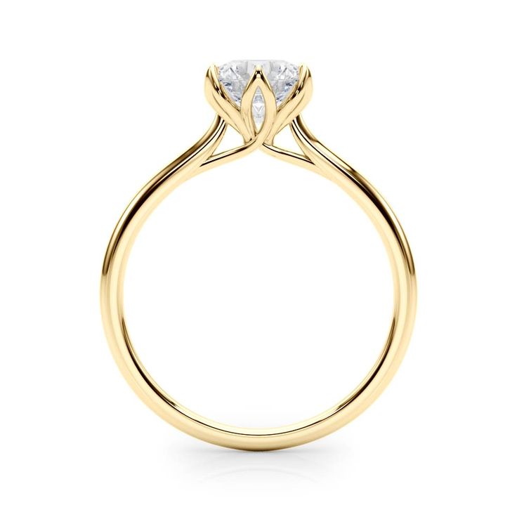 a yellow gold engagement ring with a single diamond in the center, on a white background