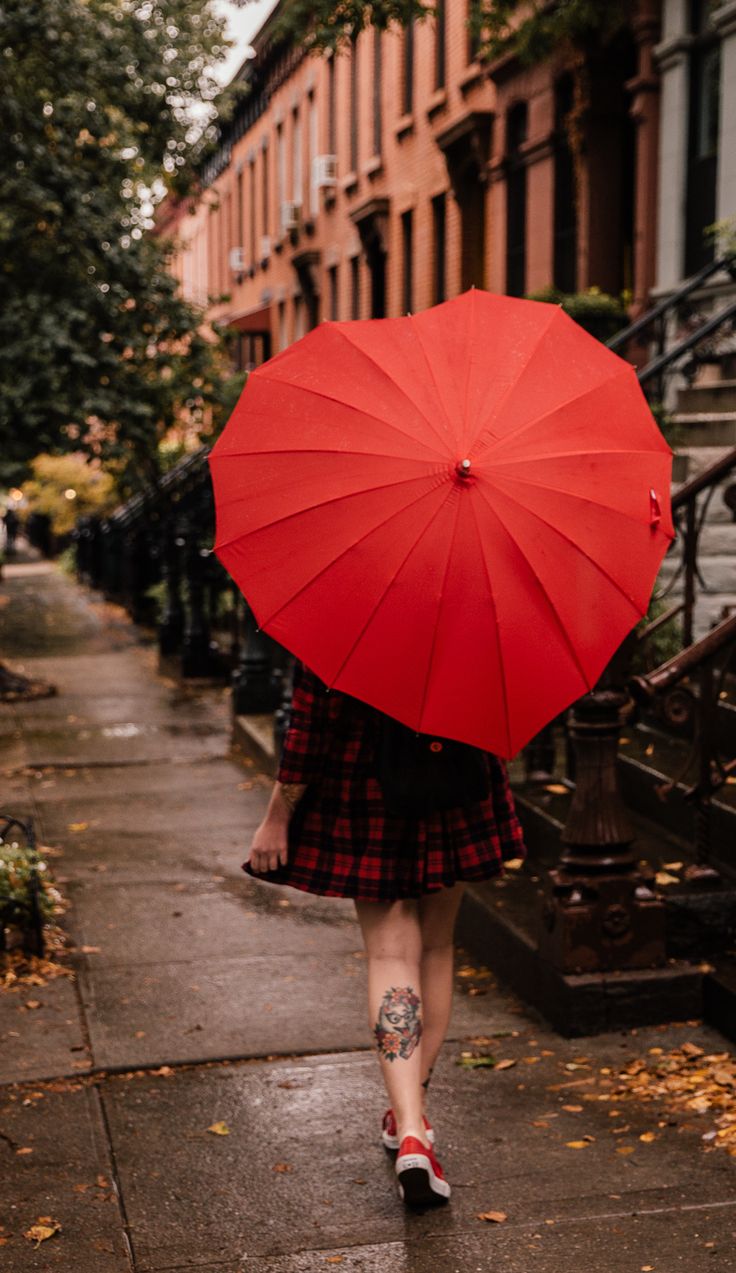 a woman walking down the street with an umbrella