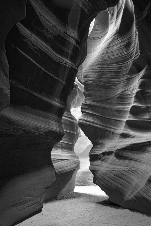 a narrow slot in the side of a rock formation with light coming through from it