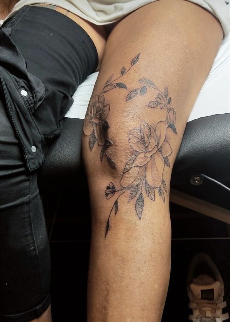 Tattoo on womens knee, wraps around the knee cap, floral tattoo with flowers and leaves. Floral Heart Knee Tattoo, Wrap Around Knee Tattoo Women, Tattoo Ideas Knee Female, Floral Knee Wrap Tattoo, Around The Knee Tattoos Women Simple, Flowers Going Up Leg Tattoo, Girl Knee Tattoo, Floral Knee Tattoos Women, Words Above Knee Tattoos Women