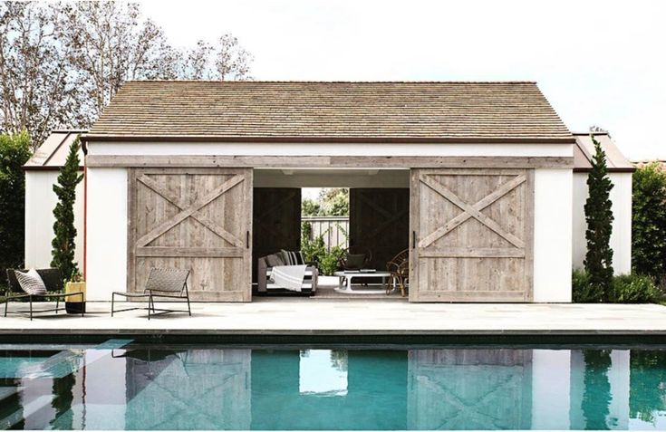 a pool house with an outdoor living area next to it