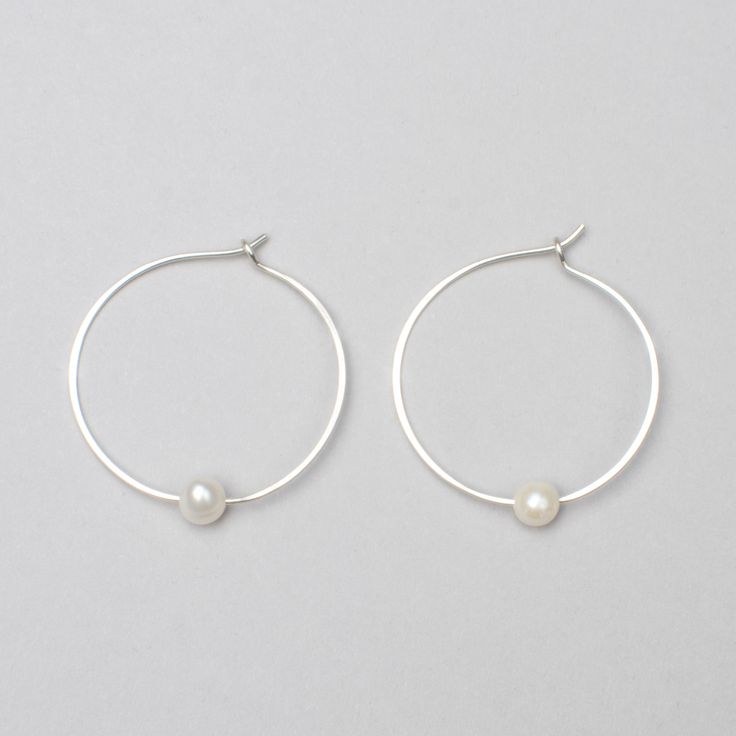 These timeless pearl hoops are made by hand and have a slight irregularity to . Wear this classic shape daily or for a night out on the town. These make a great gift, easily worn for years by earring wearers of all ages and tastes. A variation of our Classic Hoops with a pearl. Product Details: -Available in solid sterling silver or 14k gold fill -Hammered 1.25in hoop with a hook clasp sold as a pair. -Pearl is an AAA-grade freshwater pearl that measures 5-6mm. All items are hand made to order, Small Hoop Pearl Earrings For Everyday, Classic Hoop Pearl Earrings As Gift, Modern Pearl Hoop Earrings As Gift, Classic Pearl Hoop Earrings As Gift, Classic Pearl Hoop Earrings For Anniversary, Minimalist Small Hoop Pearl Earrings For Anniversary, Everyday Small Hoop Pearl Earrings, Everyday Sterling Silver Pearl Earrings, Classic Pearl Charm Hoop Earrings For Anniversary