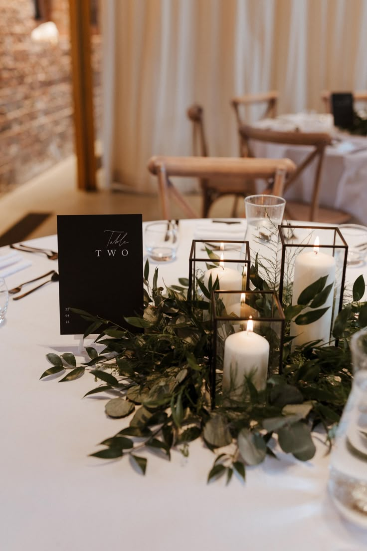 a table with candles and greenery on it