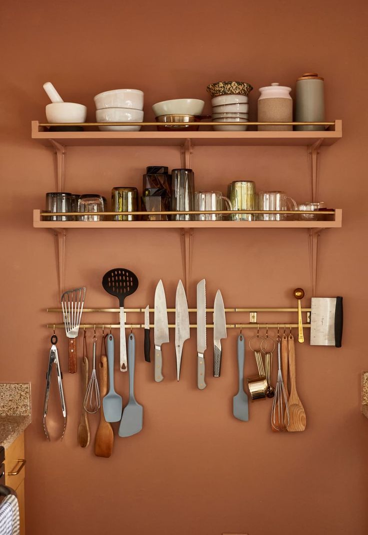 the shelves are filled with kitchen utensils and cooking implements on them, along with pots and pans