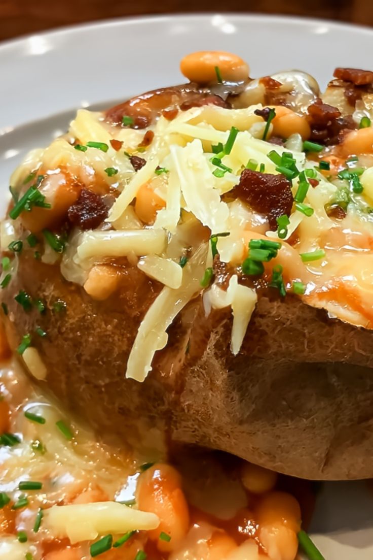 a close up of a plate of food with beans and cheese on the top,