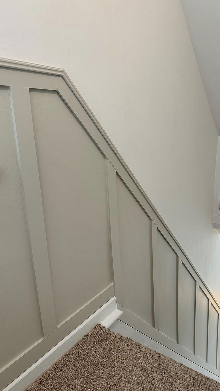 an empty room with white walls and beige carpeted stairs leading up to the second floor