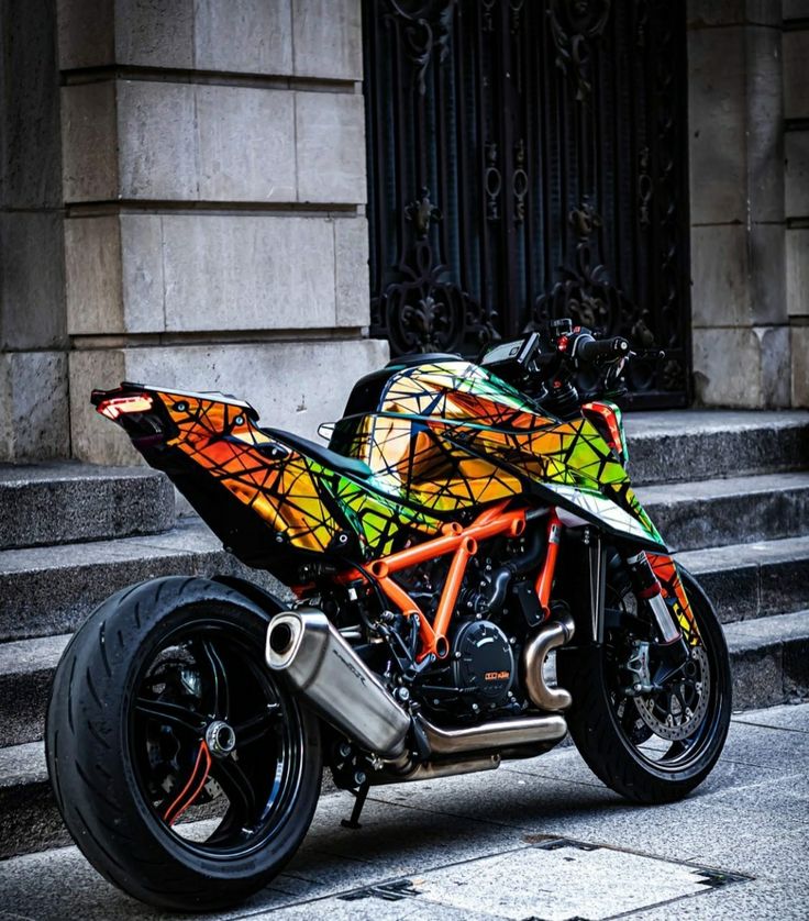 a colorful motorcycle parked on the street in front of a building