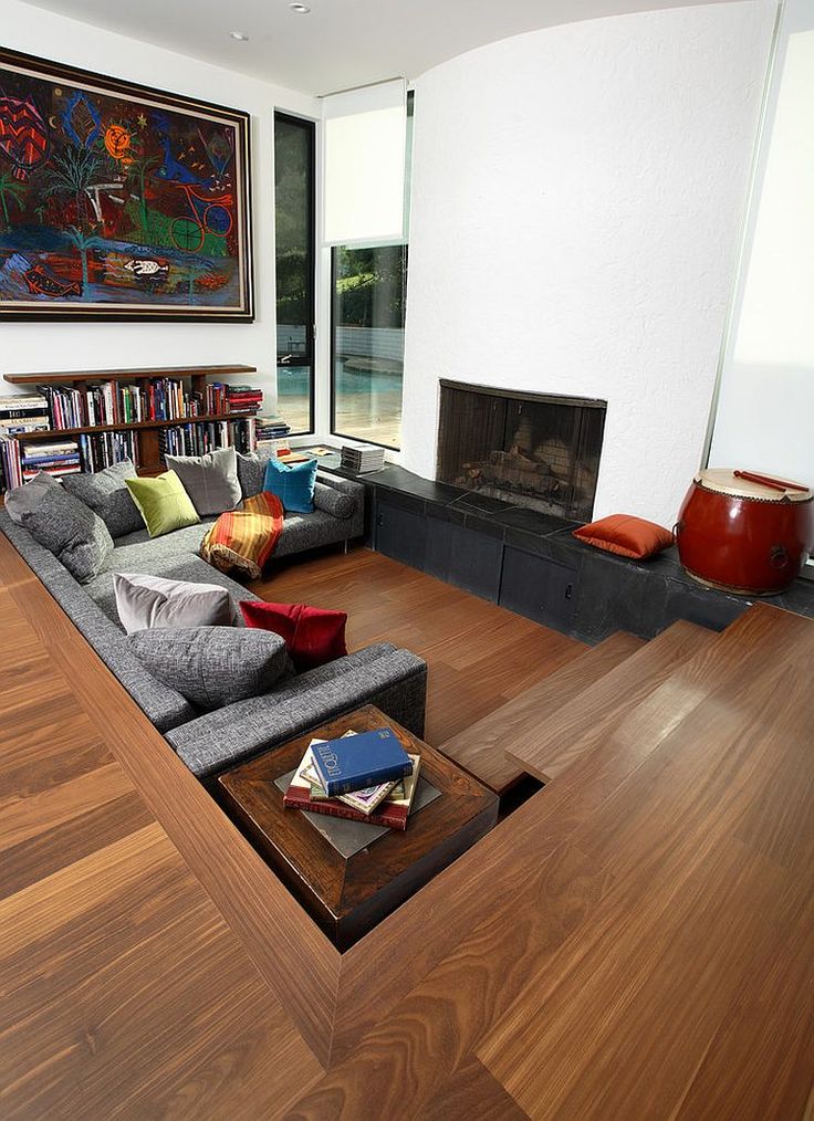 a living room filled with furniture and a fire place in the middle of a room