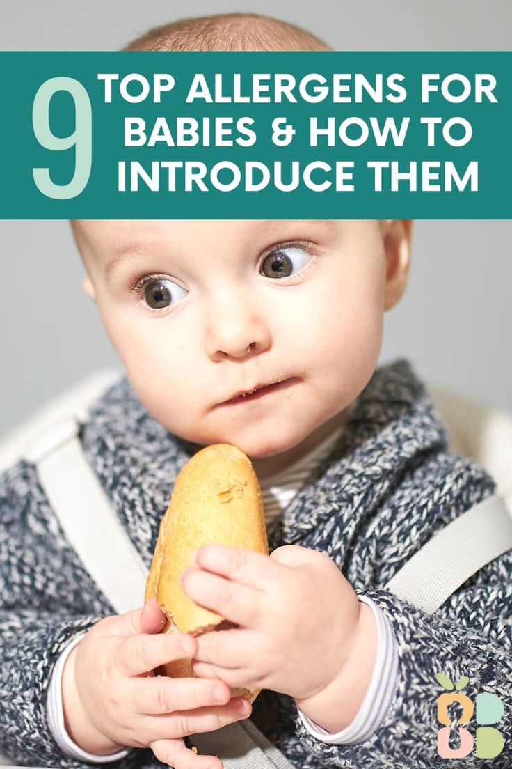 a baby holding a piece of bread with the words 9 top allergens for babies and how to introduce them