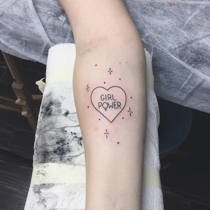 a girl power heart tattoo on the left forearm and right arm with stars around it