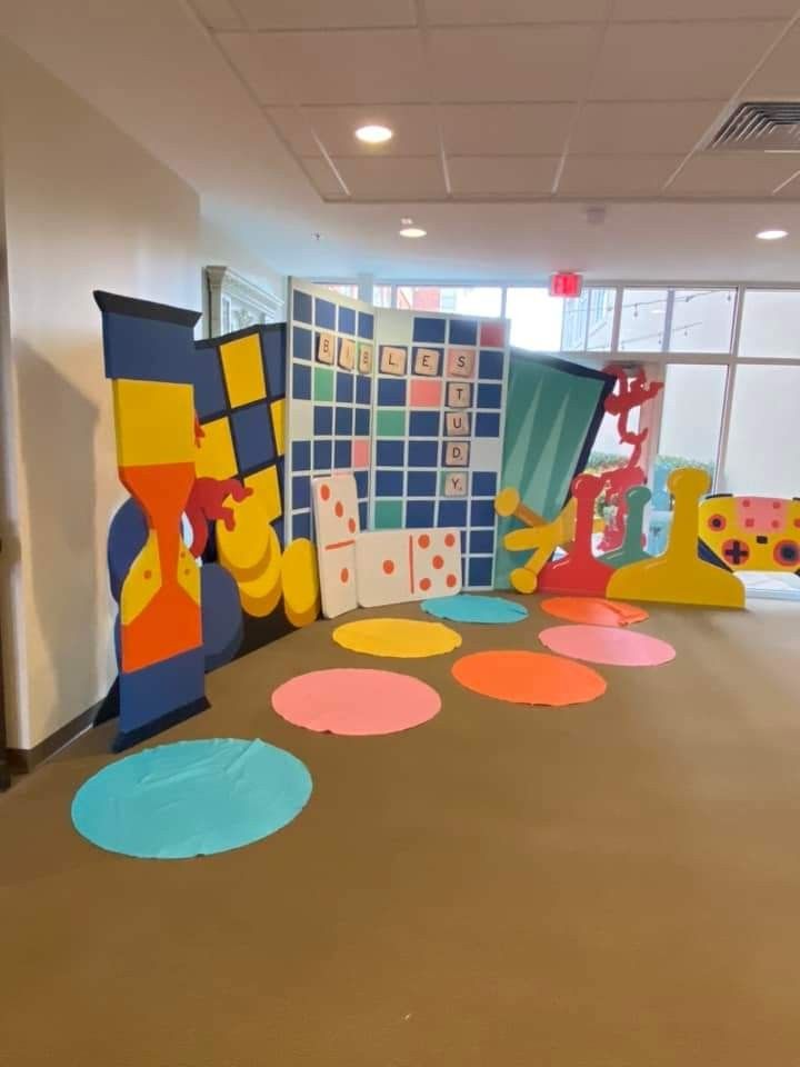 an office decorated with brightly colored paper circles and polka dot designs on the floor in front of a large window