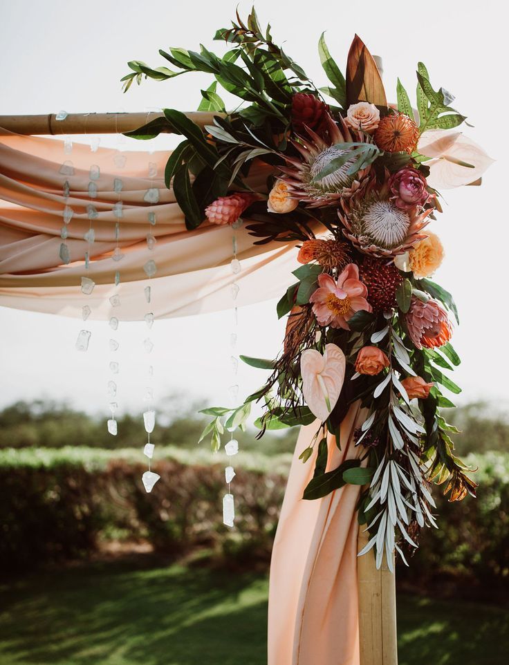 a wedding arch decorated with flowers and greenery