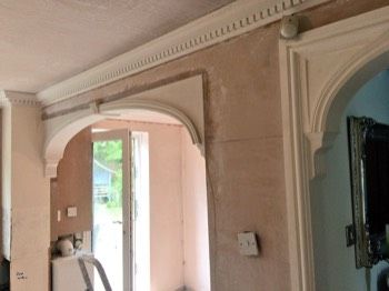 a bathroom with an arched doorway and mirror on the wall