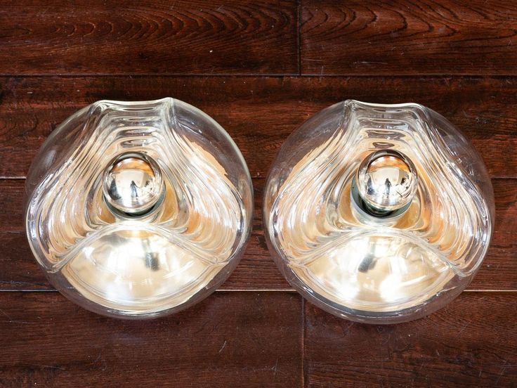 two clear glass vases sitting on top of a wooden table