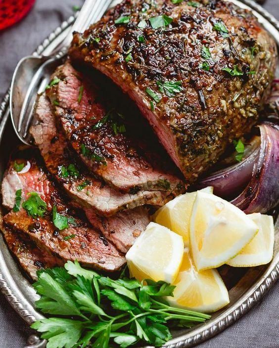 steak with potatoes and parsley on a silver platter