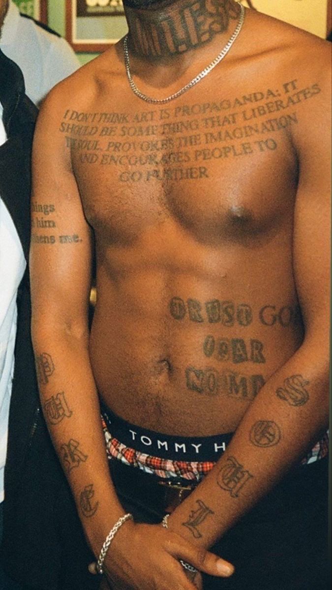 a shirtless man with tattoos on his chest