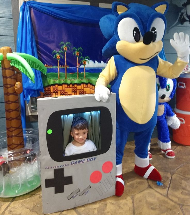 sonic the hedgehog standing next to a cardboard game box with a child in it