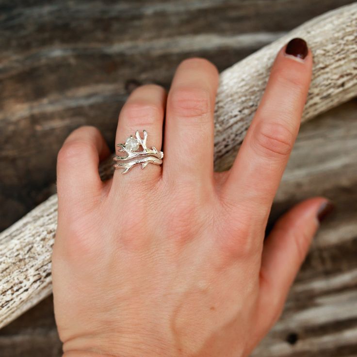 We are excited to introduce THE BUNDOLYN! We worked with an amazing artisan out of California to make this handmade beauty. This ring features a stunning raw, natural diamond surrounded by a beautiful and unique Sterling Silver bud branch. 2 rings included in this set. The band is hand-formed from a sheet of sterling silver and wire to create a stunning authentic design. ABOUT THIS RING Gemstones: Natural Raw Diamond Metal: Sterling Silver Color/Finish: Silver, Polished QUESTIONS ABOUT SIZING Go Nature-inspired Diamond Ring With Prong Setting, Nature-inspired Diamond Wedding Jewelry, Hand Forged Nature-inspired Ring, Nature-inspired Hand Forged Ring, Nature-inspired Diamond Ring As A Gift, White Gold Nature-inspired Jewelry For Promise, Nature-inspired Untreated Rings For Promise, Nature-inspired Sterling Silver Jewelry For Wedding, Nature-inspired Sterling Silver Jewelry For Weddings