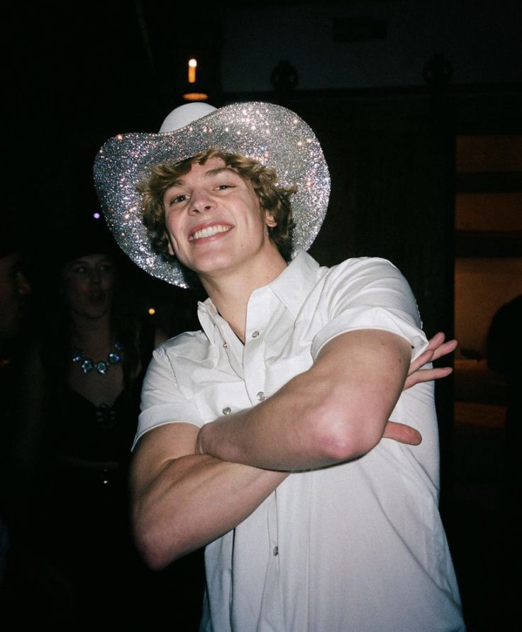 a man wearing a white cowboy hat standing in front of a woman with her arms crossed