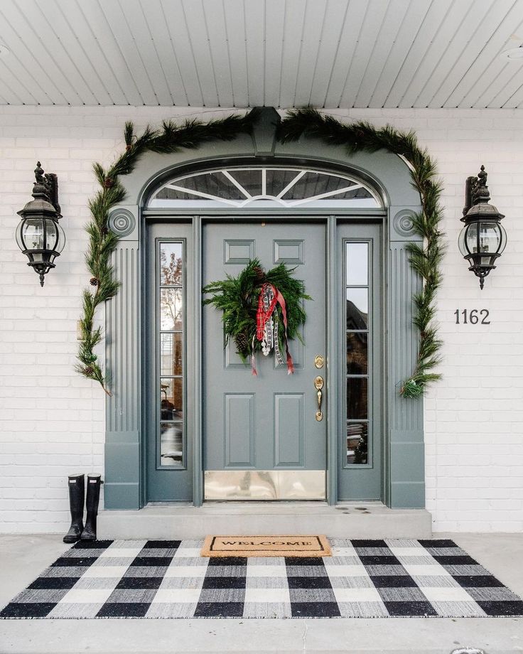 the front door is decorated with wreaths and lights