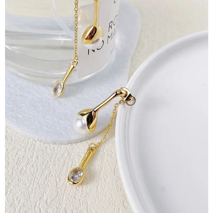 Introducing the Selena Pearl Earrings, a modern interpretation of classic elegance. These stunning earrings feature a large pearl adorned with a drop-style single stone, creating a captivating and contemporary design that is sure to turn heads. Crafted with meticulous attention to detail, the Selena Pearl Earrings are plated with luxurious 18K gold over stainless steel, ensuring a radiant and long-lasting finish. Their unique combination of elements adds a touch of sophistication to any outfit, Modern White Pearl Earrings With Pendant, Modern White Pearl Pendant Earrings, Modern Pearl White Earrings With Pearl Drop, Modern Pearl White Earrings With Pearl Charm, Modern Teardrop Pearl Pendant Earrings, Modern Teardrop Pearl Earrings With Pearl Charm, Modern Dangle Earrings With Pearl Drop, Modern Teardrop Earrings With Pearl Charm, Modern Pearl Pendant Earrings