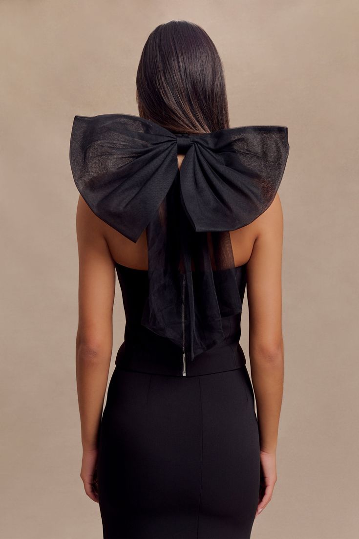 Adorned with a bow. The MARYAM Tulle Bow Top is a statement piece that combines elegance with a touch of whimsy. Featuring a princess neckline and a fitted bodice, this top offers a flattering and sophisticated silhouette. The mesh functional halter adds a delicate touch, while the tulle-lined back bow creates a stunning focal point. With a centre-back zip for easy wear, this top pairs beautifully with an A-line skirt for a chic and graceful ensemble. Fully lined for comfort, the Maryam Tulle Bo Tulle Bow, Tulle Bows, Bow Top, A Princess, Fitted Bodice, Easy Wear, A Line Skirt, A Line Skirts, Focal Point