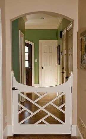 an entryway with a white gate and green walls