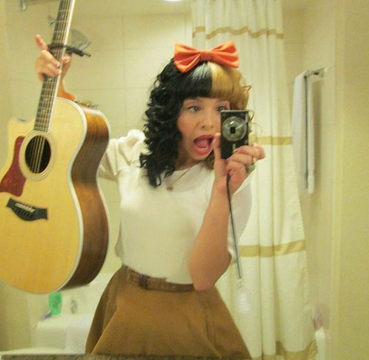 a woman taking a selfie while holding a guitar