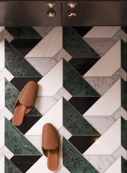 a pair of brown slippers sitting on top of a tiled wall