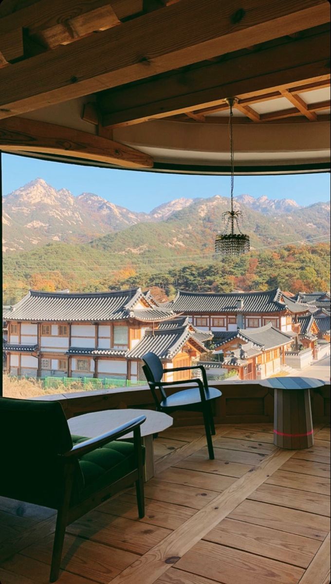 a room with a large window looking out at the mountains and houses in the distance