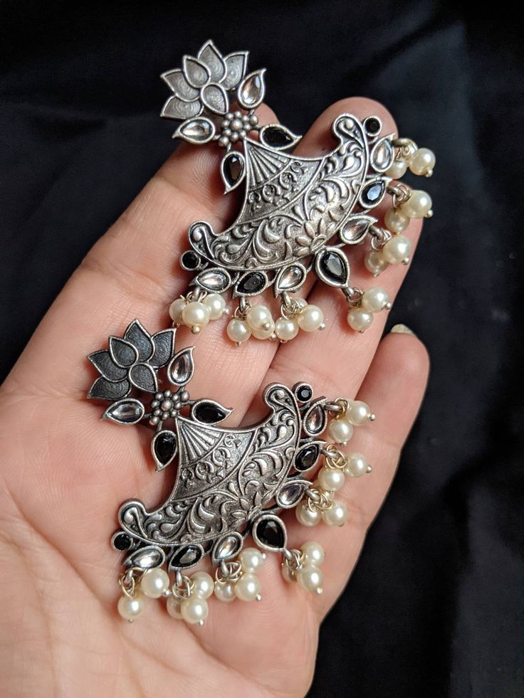 Add charm and charisma to your beautiful personality with these exquisitely designed and handcrafted high quality stone studded silver look alike earrings lined with fine lustrous pearls. Pair them up with any formal or semi formal attire and gather compliments wherever you go. Suitable for both casual and dressy occasions. Colour: Antique Length 5 cm Width 4cm Each earring weighs 12 gms (light weight) Note: All in stock items will be shipped from New Delhi, India within 2-3 business days after Elegant Handmade Silver Chandbalis, Elegant Silver Handmade Chandbalis, Traditional Silver Pearl Earrings, Traditional Silver Sterling Pearl Earrings, Traditional Silver Sterling Silver Pearl Earrings, Traditional Sterling Silver Pearl Earrings, Handmade Kundan Silver Earrings, Handmade Silver Kundan Earrings, Silver Kundan Fusion Danglers