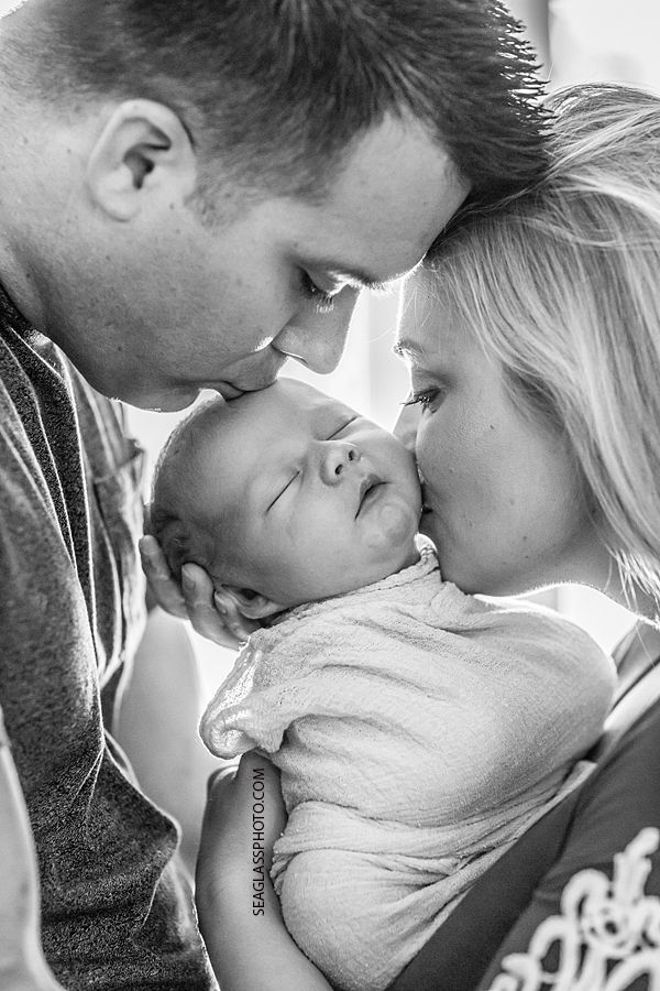 a man and woman holding a baby in their arms