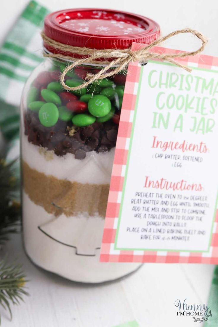 a mason jar filled with christmas cookies in a jar and a tag on the top