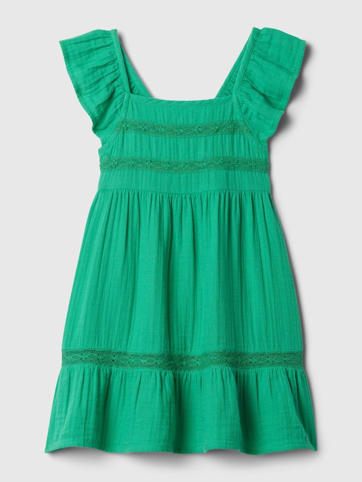 a green dress with ruffles on the shoulders