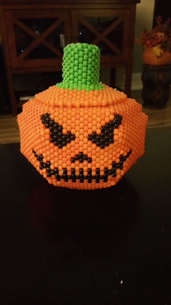 a pumpkin made out of beads sitting on top of a table